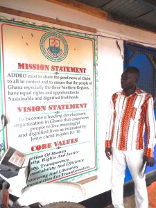 Emmanuel standing in front of sign